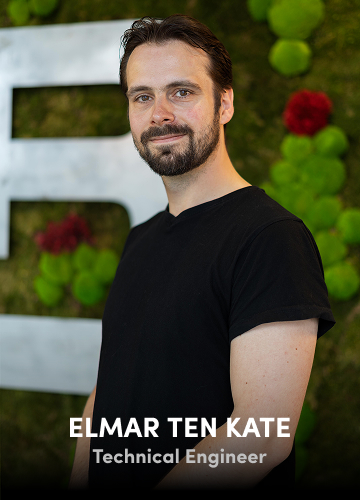 Portrait of Elmar Ten Kate, Technical Engineer, in a black shirt with a green wall background.