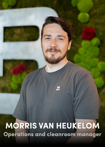 Portrait of Morris van Heukelom, Operations and Cleanroom Manager, wearing a grey shirt with a green wall background.