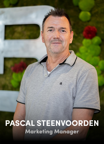 Portrait of Pascal Steenvoorden, Marketing Manager, wearing a grey shirt with a green wall backdrop.