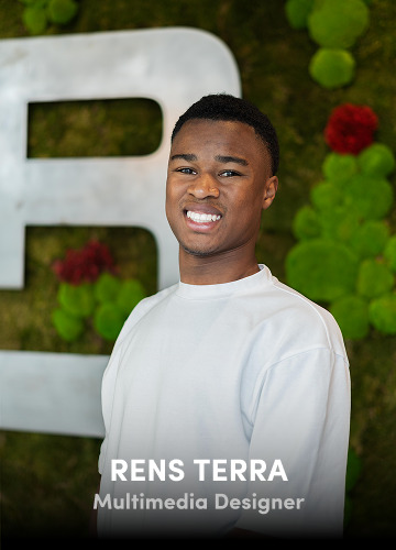 Portrait of Rens Terra, Multimedia Designer, wearing a white shirt with a green wall background.