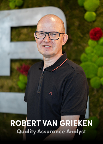 Portrait of Robert van Grieken, Quality Assurance Analyst, in a black polo shirt with a green wall background.